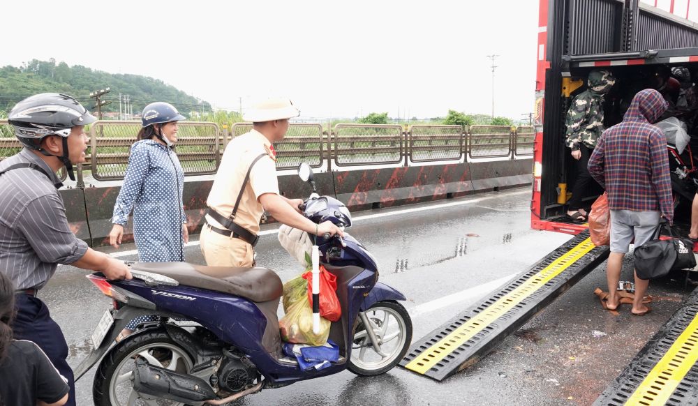 CSGT Thanh Hoa ho tro, day xe may len thung o to de di qua doan duong ngap. Anh: Quach Du