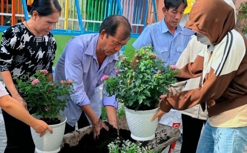Teachers and workers of Kindergarten 12, Binh Thanh Ward, implement the project "School brilliant with flowers". Photo: Duc Long