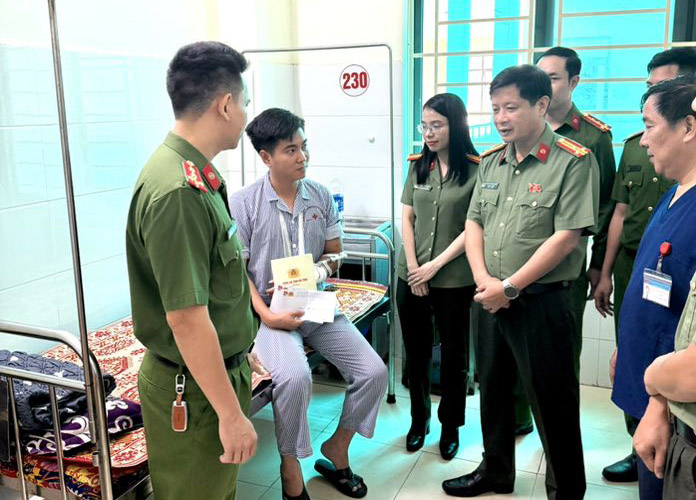 ハティン省警察の代表者が、台風5号の被害を住民が復旧するのを支援する過程で負傷したグエン・ヴァン・グエン兵士を訪問し、励ましています。写真:ハティン省警察.