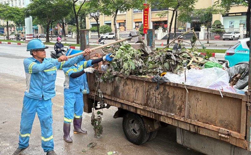 Environmental sanitation workers collect garbage on Me Tri Street on the afternoon of August 27. Photo: Bao Han