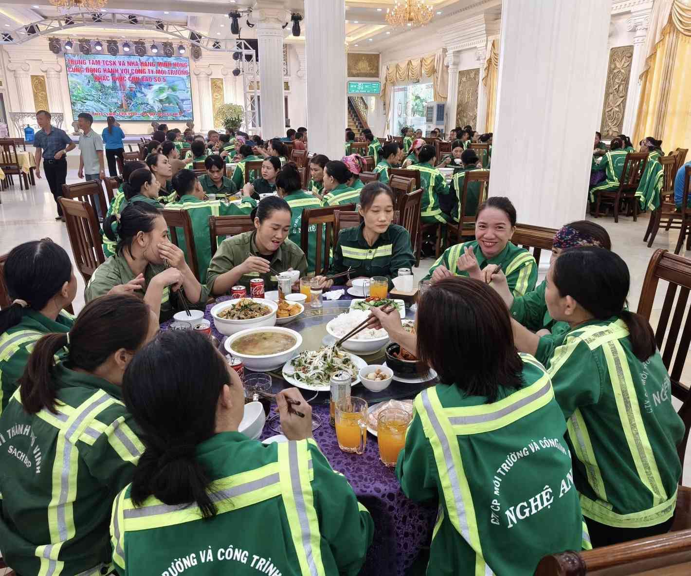 Hon 200 cong nhan Cong ty CP Moi truong va cong trinh do thi Nghe An du bua com do chu nha hang Minh Hong moi. Anh: Quang Dai
