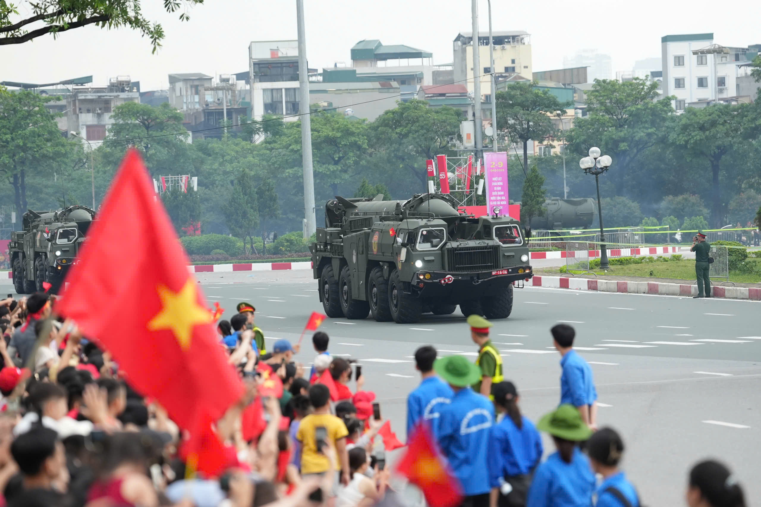16h30: Doan xe phao Quan su banh lop, xe dac chung Cong an xuat phat tu Truong dua F1 vao trung tam thanh pho de so duyet dieu binh, dieu hanh  dip ky niem 80 nam Quoc khanh.  Den khoang 16h45, troi do mua lon, nhieu nguoi che o, mac ao mua de tiep tuc theo doi doan xe di chuyen.  Tieng loa phat ra tu dan khi tai: “Cam on ba con, chuc ba con khoe“. Nguoi dan lien tuc vay tay, ho reo dap lai tinh cam cua can bo, chien si Quan doi va Cong an. Anh: Huu Chanh