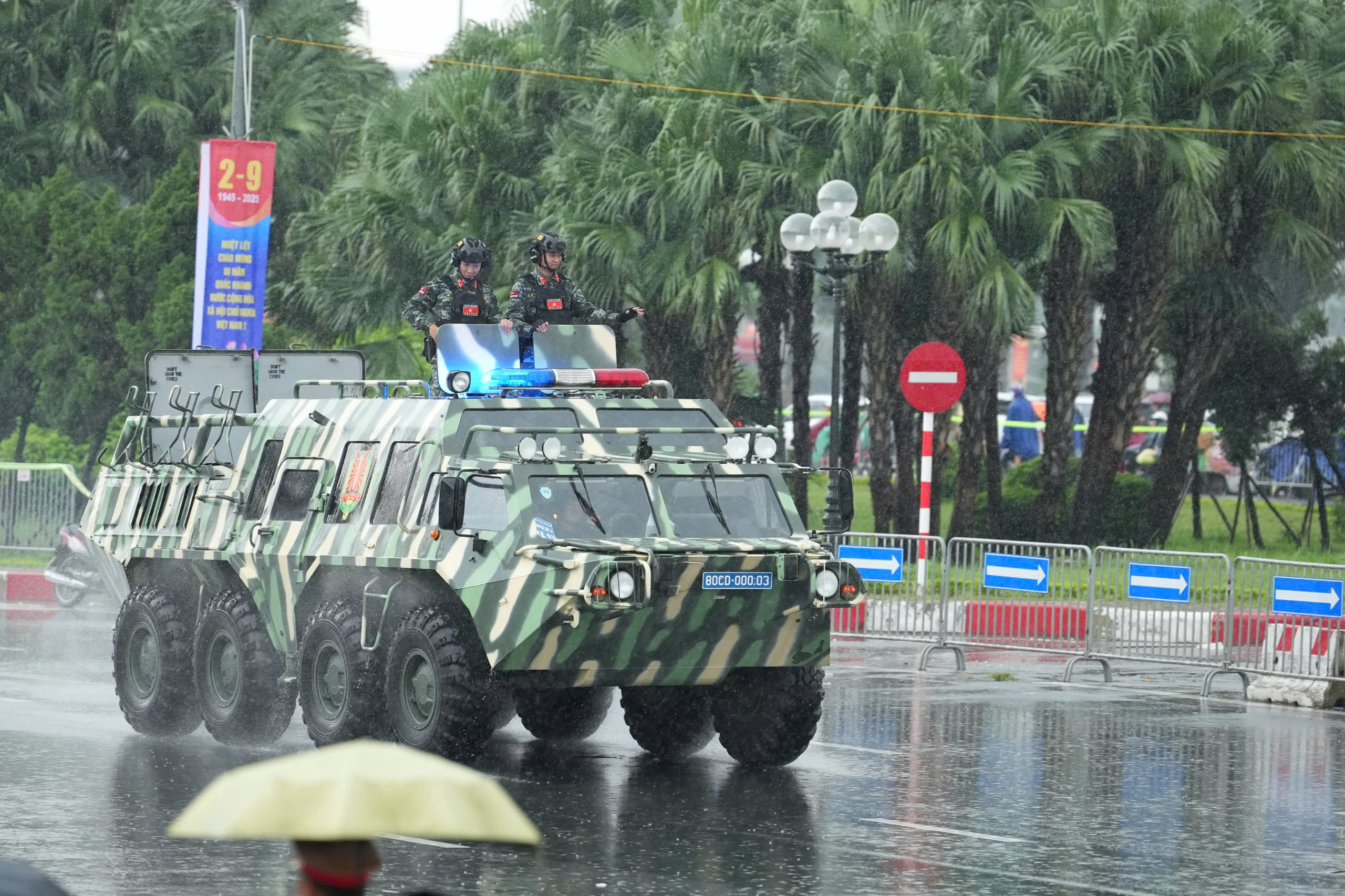 16h30: Doan xe phao Quan su banh lop, xe dac chung Cong an xuat phat tu Truong dua F1 vao trung tam thanh pho de so duyet dieu binh, dieu hanh  dip ky niem 80 nam Quoc khanh.  Den khoang 16h45, troi do mua lon, nhieu nguoi che o, mac ao mua de tiep tuc theo doi doan xe di chuyen.  Tieng loa phat ra tu dan khi tai: “Cam on ba con, chuc ba con khoe“. Nguoi dan lien tuc vay tay, ho reo dap lai tinh cam cua can bo, chien si Quan doi va Cong an. Anh: Huu Chanh