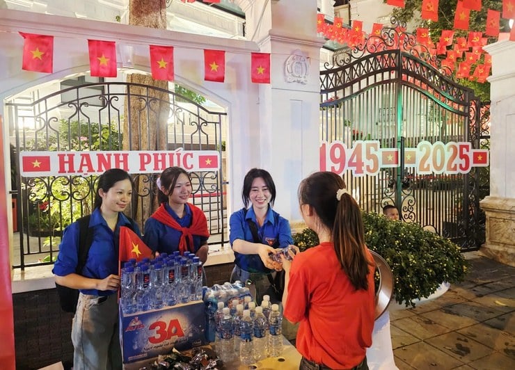 首都報道センターに「チェックイン」し、9月28日革命と建国80周年記念式典、パレード、デモを見学する際、国民と観光客に無料の飲料水を贈呈する活動。写真:Pham Linh