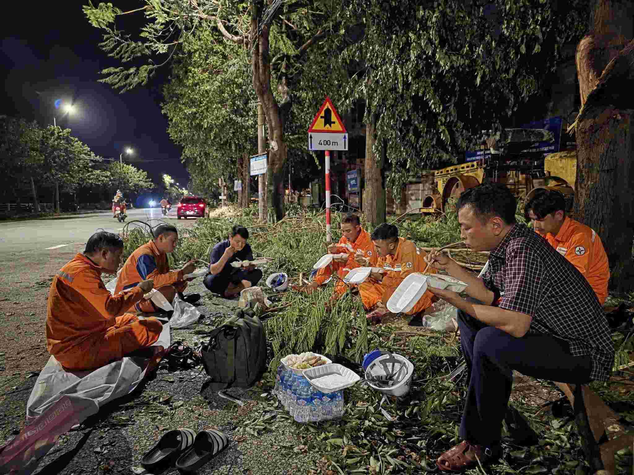 Cong nhan dien luc Nghe An tranh thu an com de khac phuc su so luoi dien sau bao so 5. Anh: Ngoc Anh