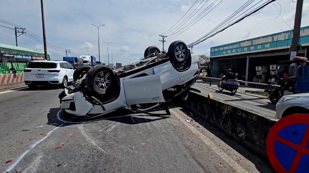 Scene of a 7-seat car hitting a median strip and overturning on a bridge slope in Ho Chi Minh City