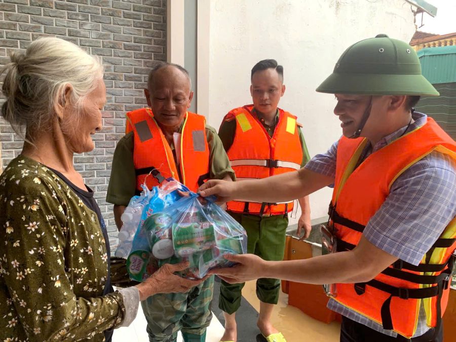Công an phường Hàm Rồng, Thanh Hóa hỗ trợ người dân trong bão lũ. Ảnh: CATH