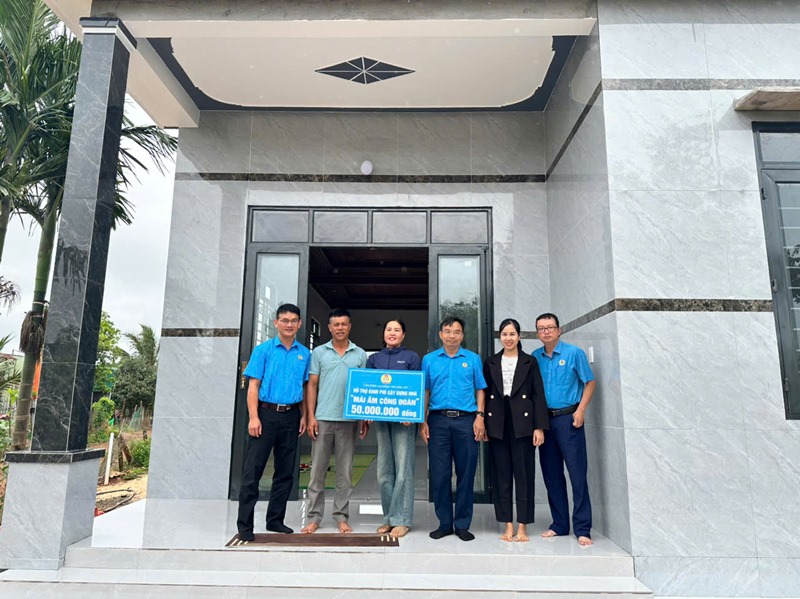 새로 지어진 집을 앞두고 조합원 로 티 히엡은 간라 주택 건설 지원금을 기쁘게 받았습니다. 간라 노동조합의 따뜻한 집 사진: 레 주옌