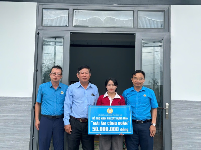 Chi H’Lo Ra Mlo nhan kinh phi ho tro 50 trieu dong xay dung nha ” Mai am Cong doan“. Anh: Le Duyen
