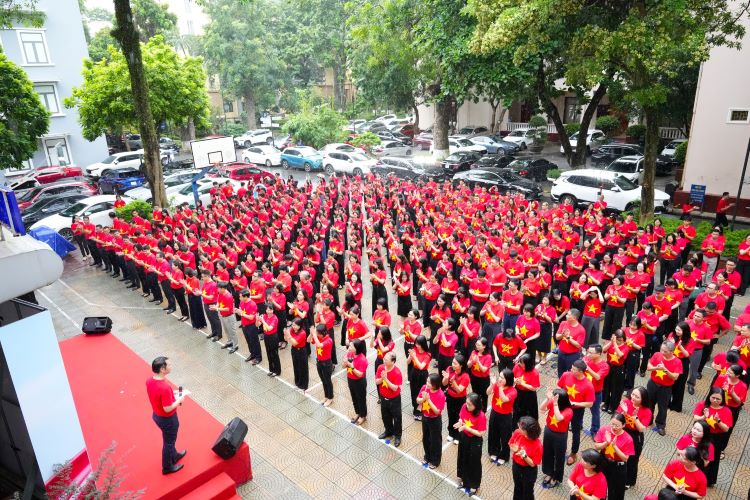 Can bo, giang vien, nhan vien Hoc vien Ngan hang mac ao co do sao vang trong buoi le chao co dau tuan. Anh: Nha truong cung cap