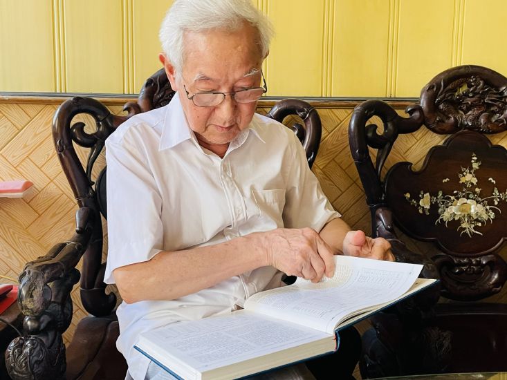 Mr. Pham Quy Mui next to the historical books he compiled. Photo: Mai Huong