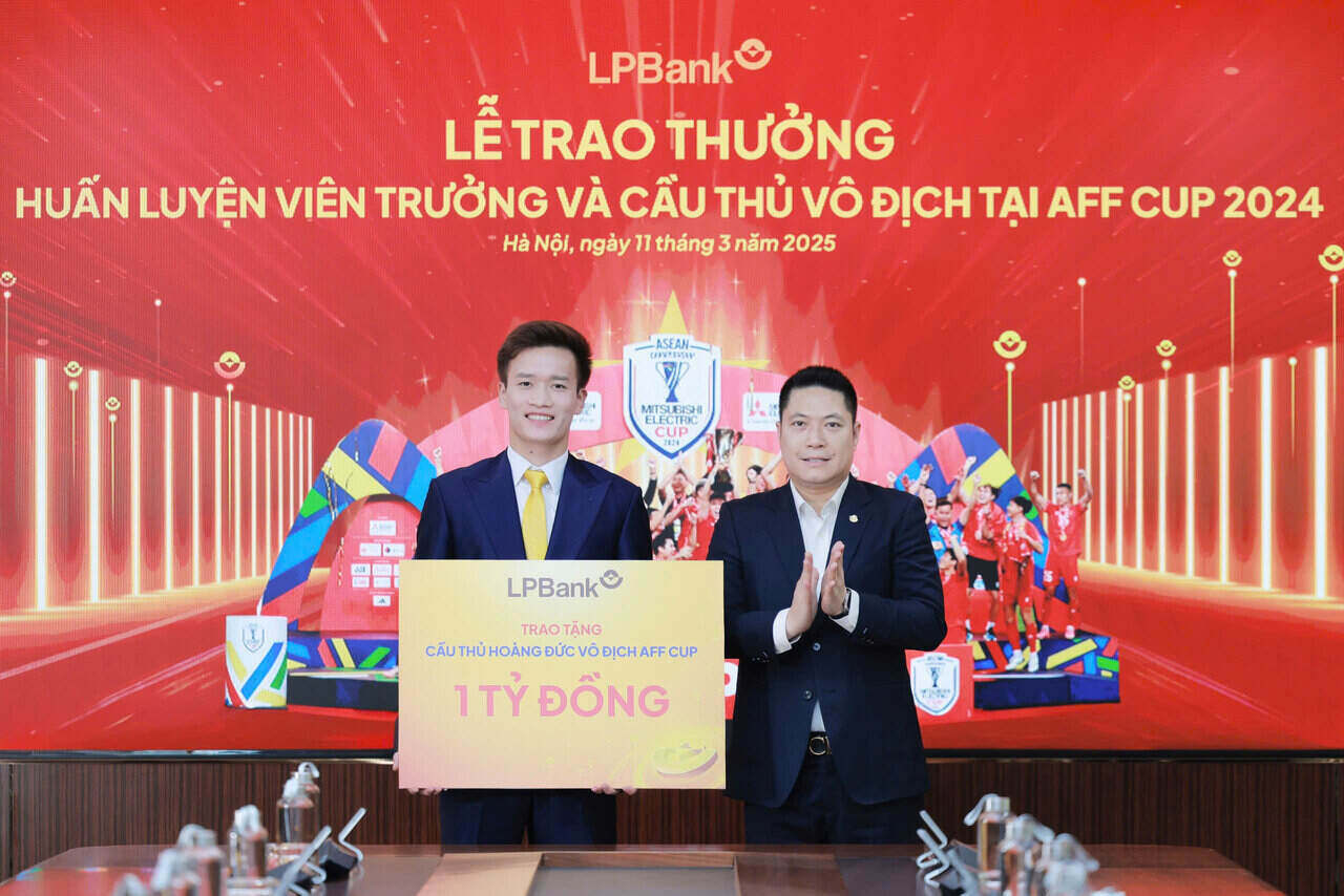 Ong Nguyen Van Thuy, Pho Chu tich HDQT LPBank (phai) trao tang 1 ti dong cho cau thu Hoang Duc