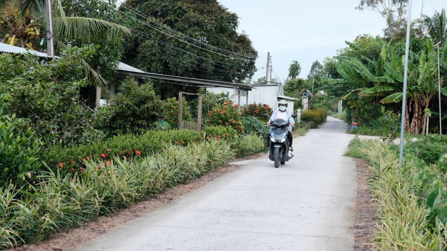 Tam long Vang XHTT 기금이 후원하는 Kenh Xang Nang Mau 2 도로를 통행하는 시민들. 사진: My Ly