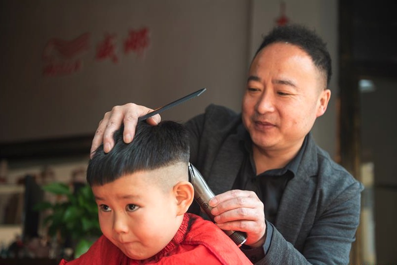 Un bebe siendo cortado de pelo en una peluqueria en China. Foto: Xinhua