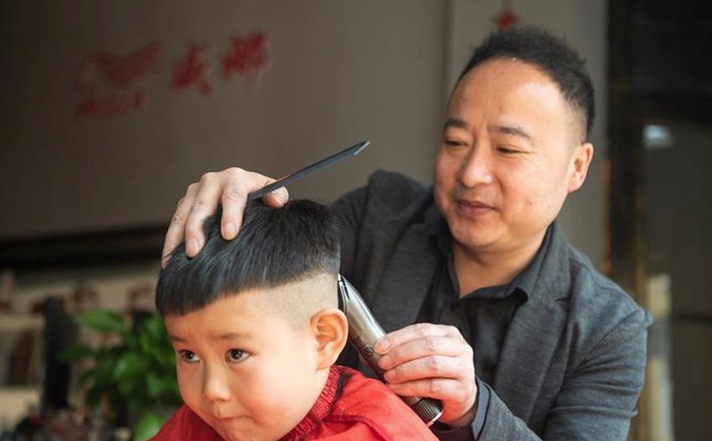 A baby is having his hair cut in a shop in China. Photo: Xinhua