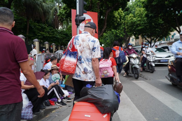 Nguoi dan mang theo vali, Balo, leu bat, ao mua... cung nhieu vat dung can thiet de san sang bam tru via he “xuyen dem“, cho doi cac doan dieu binh den sang mai. Anh: Thuy Linh