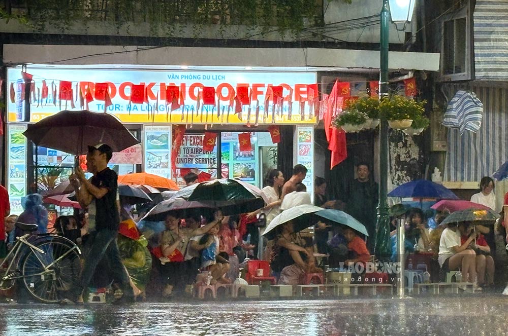 Nguoi dan va du khach doi mua giu cho xem dieu binh tai nut giao Cua Nam - Hang Bong toi 29.8. Anh: Y Yen