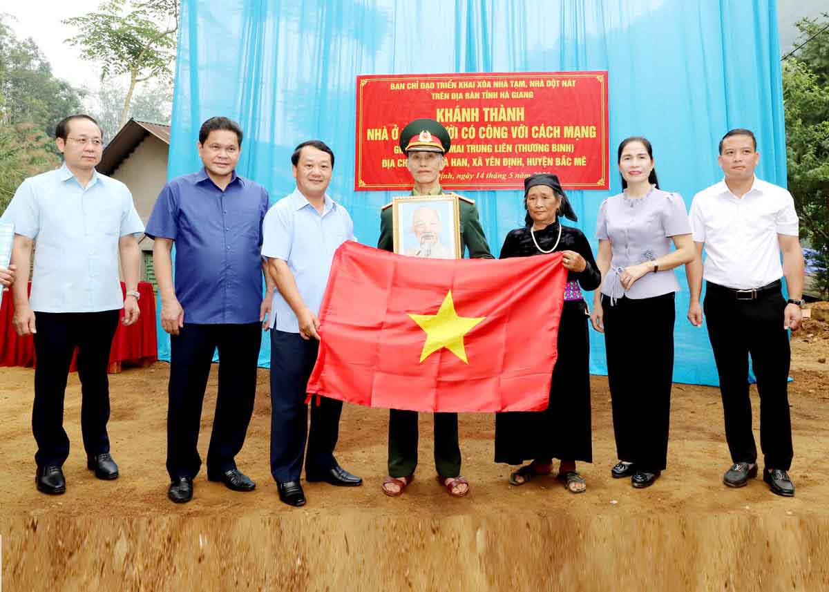 Bi thu Tinh uy Tuyen Quang Hau A Lenh (thu 3 tu trai) trao co To quoc va anh Bac Ho tai le khanh thanh nha o cho ho gia dinh chinh sach tren dia ban. Anh: Van Nghi.