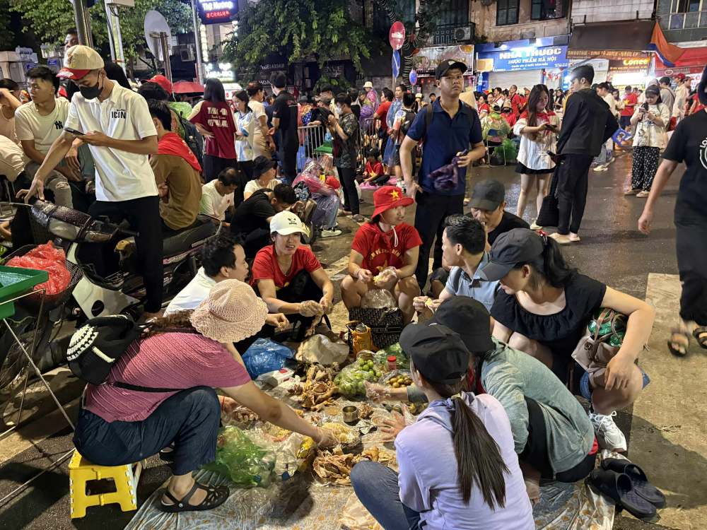 Nguoi dan tranh thu an sang truoc gio dien ra tong duyet dieu binh, dieu hanh A80. Anh: Y Yen