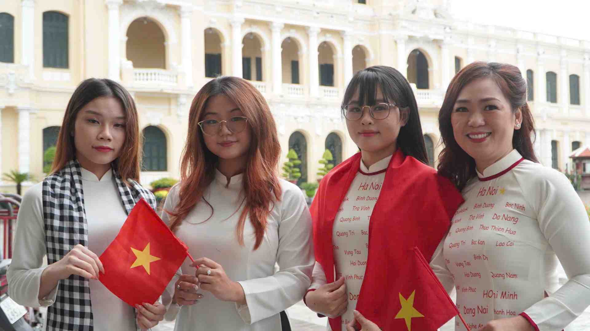 The girls in traditional ao dai proudly captured moments with the national flag. Photo: Chan Anh