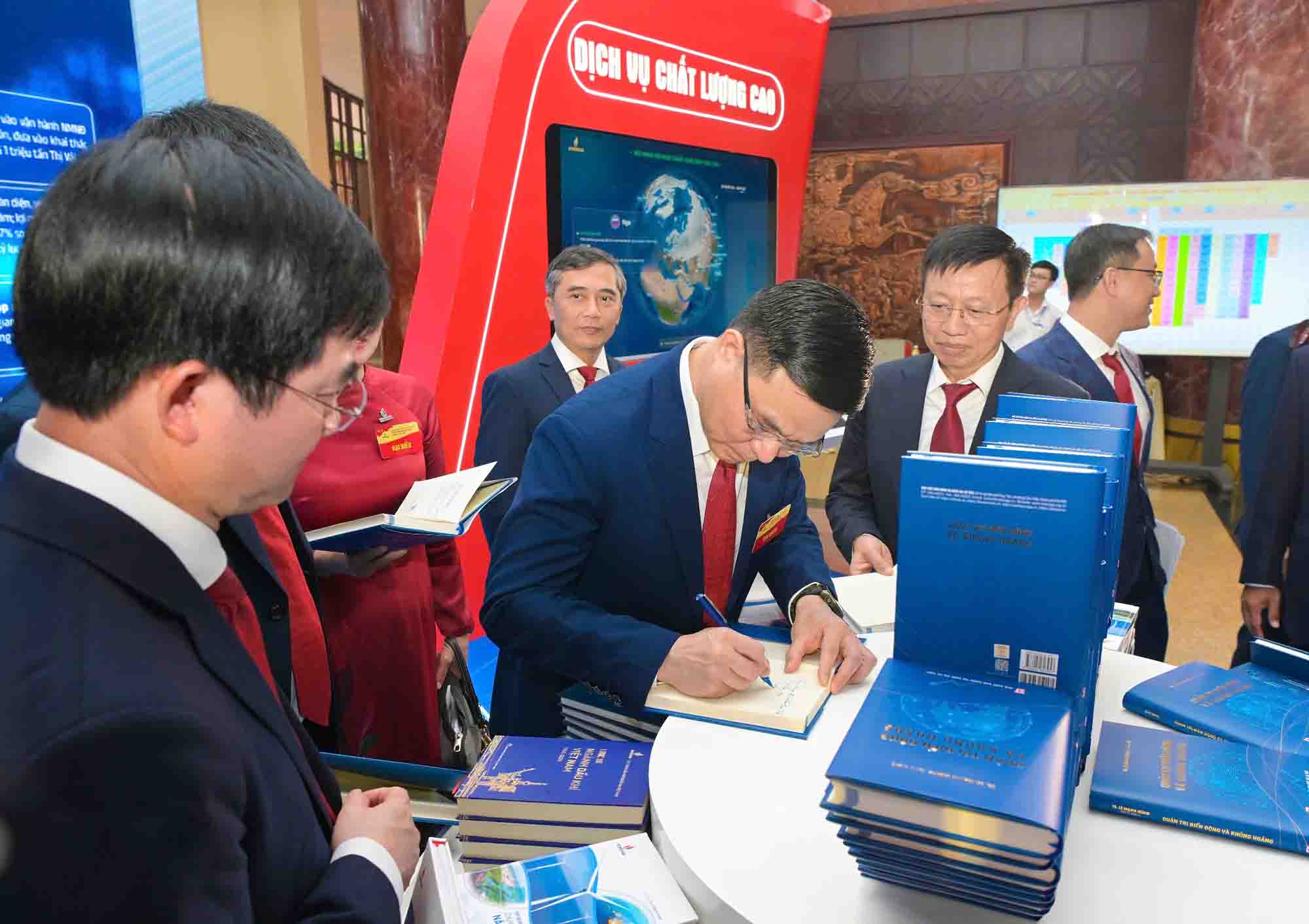 Le Manh Hung 박사가 대표들에게 '변동 및 위기 관리' 책에 서명하고 있습니다. 사진: Manh Chung.