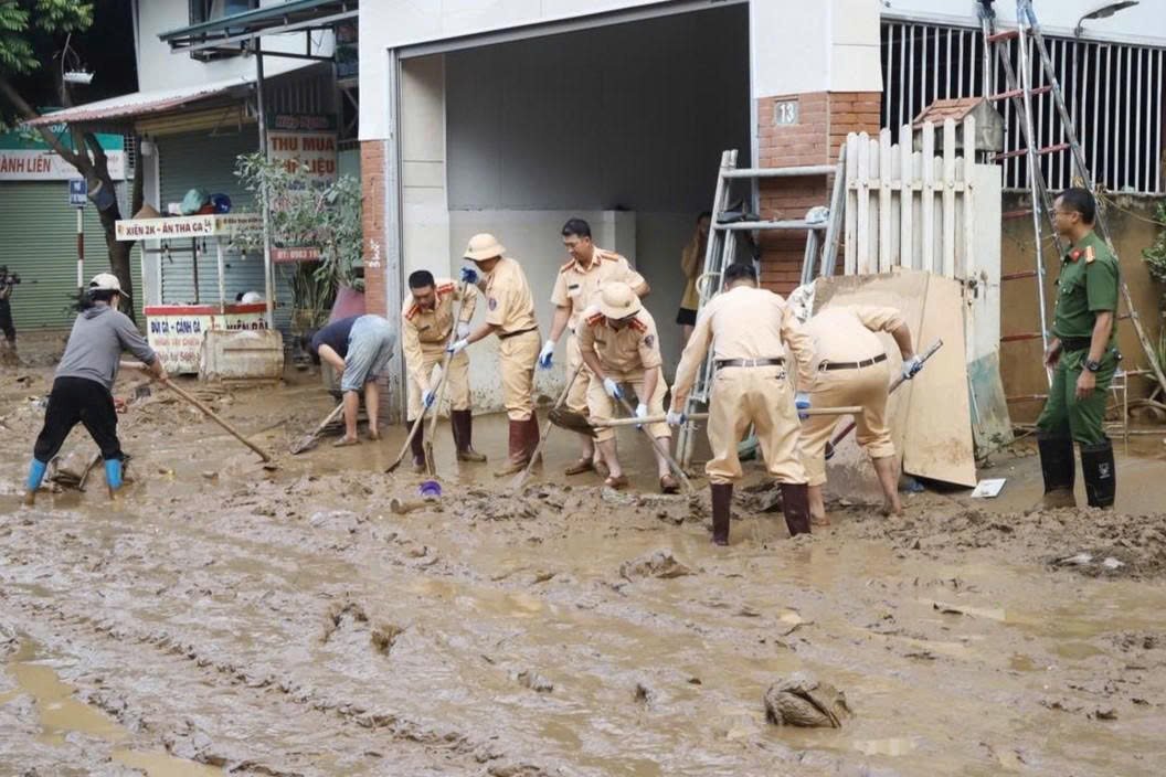 Traffic police help people clean up mud on traffic routes in Son La after floods. Photo: Truong Son