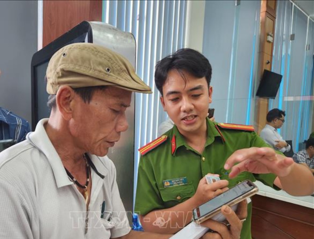 Police officers instruct people to apply for criminal records on the VNeID application. Photo: VNA