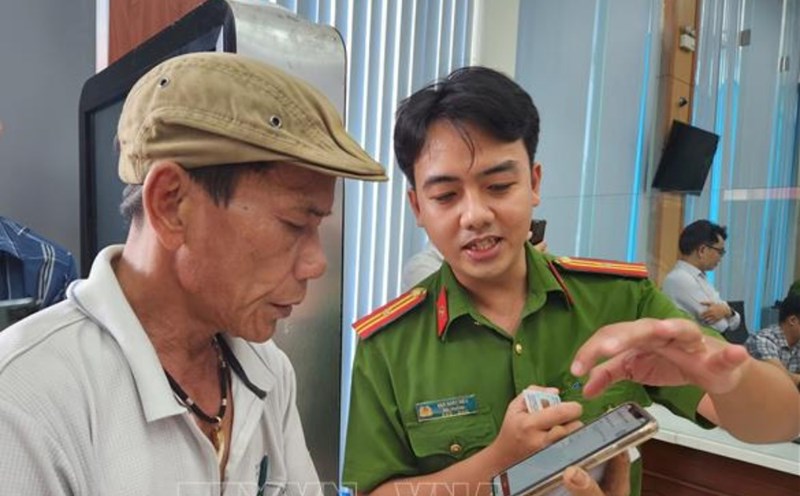 Police officers instruct people to apply for criminal records on the VNeID application. Photo: VNA