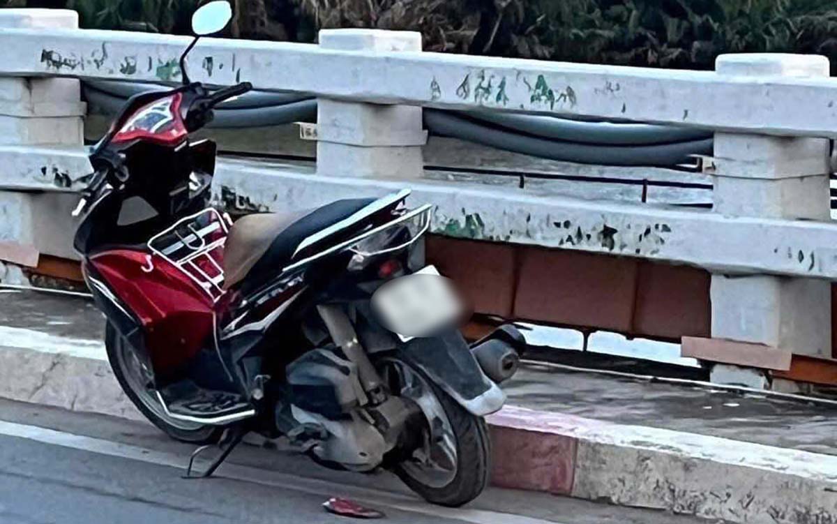 Une jeune femme conduisant une moto immatriculee a Ho Chi Minh-Ville monte sur le pont puis saute soudainement dans la riviere Tac. Photo : Dong Hoang
