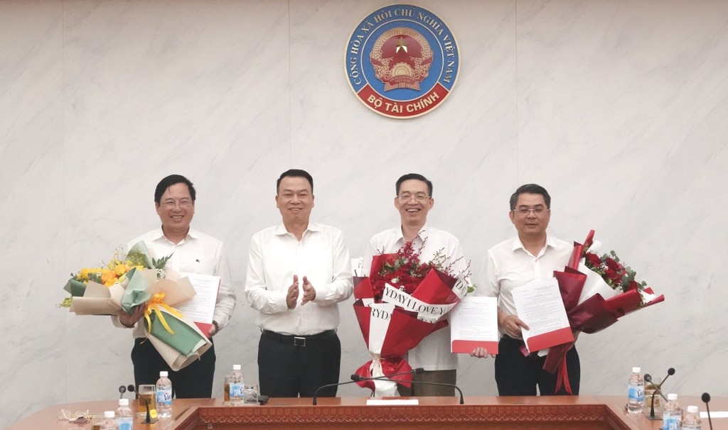 Thu truong Bo Tai chinh Nguyen Duc Chi trao quyet dinh va tang hoa cho cac dong chi duoc dieu dong, bo nhiem. Anh: Bo Tai chinh