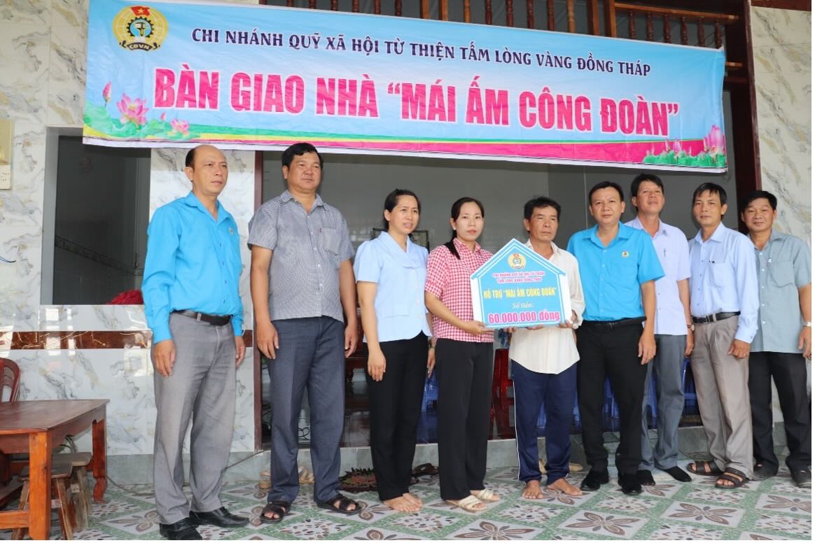 Dai dien LDLD tinh cung chinh quyen dia phuong xa Binh Thanh chup anh luu niem cung gia dinh doan vien Nguyen Thi Tho. Anh: Luu Hung.