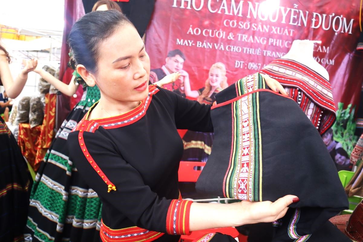 Chi Nguyen Thi Duom dua hoa van tho cam len trang phuc. Anh: Thanh Quynh