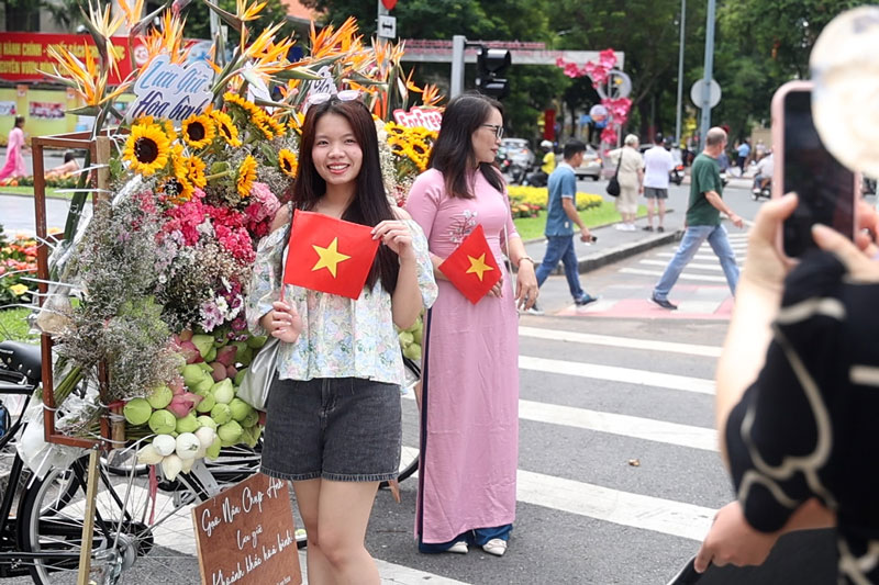 Ciudad Ho Chi Minh luce radiante de coches de novia de otoño celebrando el Dia Nacional la gente disfruta haciendo check-in