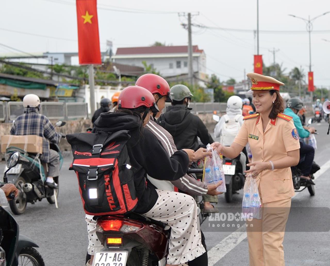 La police de la circulation de la province de Dong Thap distribue gratuitement de l'eau potable en bouteille et des serviettes froides aux habitants rentrant chez eux a l'occasion de la fete nationale du 2 septembre. Photo : Quyen Pham