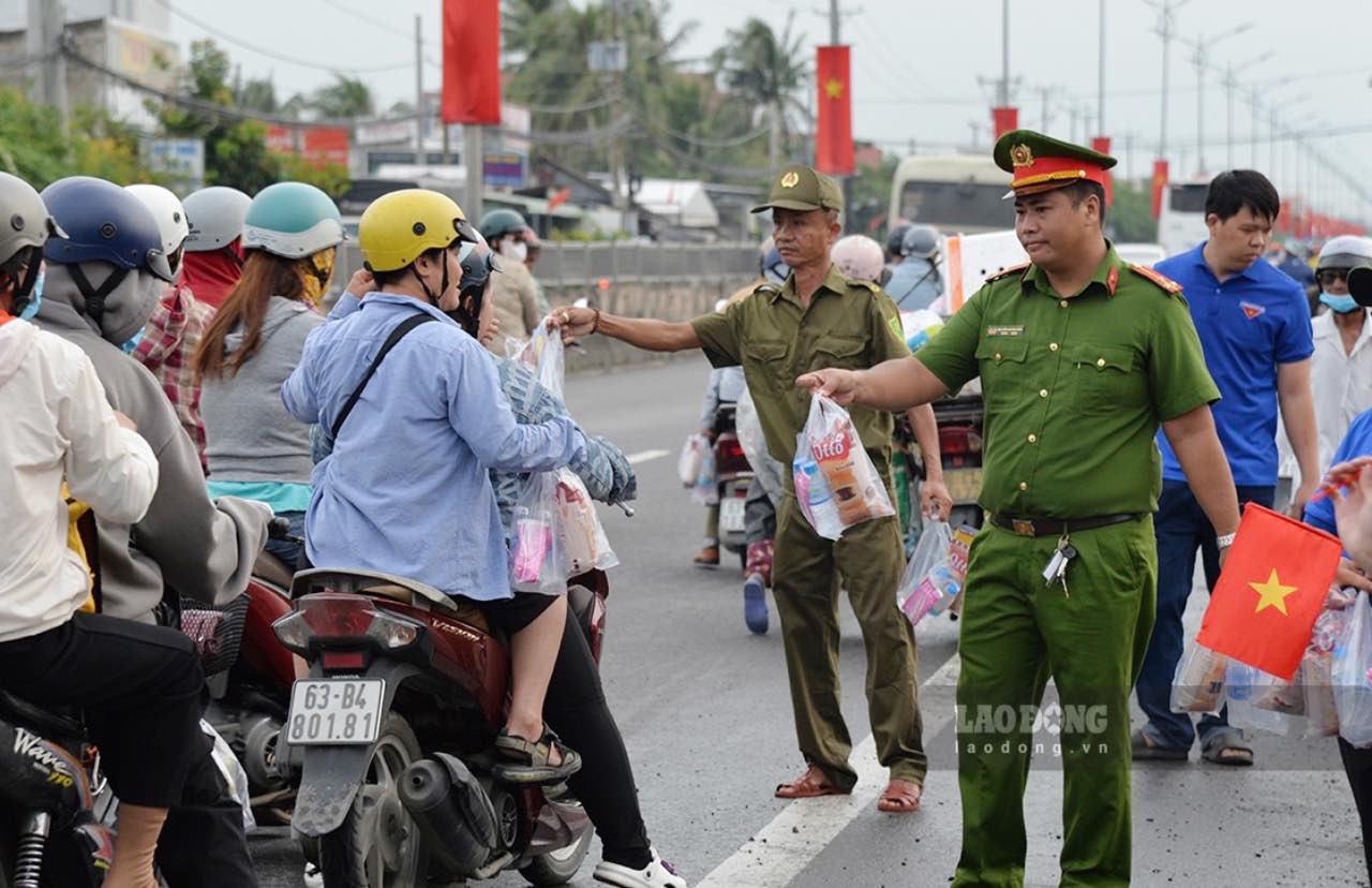 Luc luong Cong an cua tinh Dong Thap phat mien phi nuoc uong dong chai, khan lanh cho nguoi dan ve que dip Le Quoc khanh 2.9. Anh: Quyen Pham