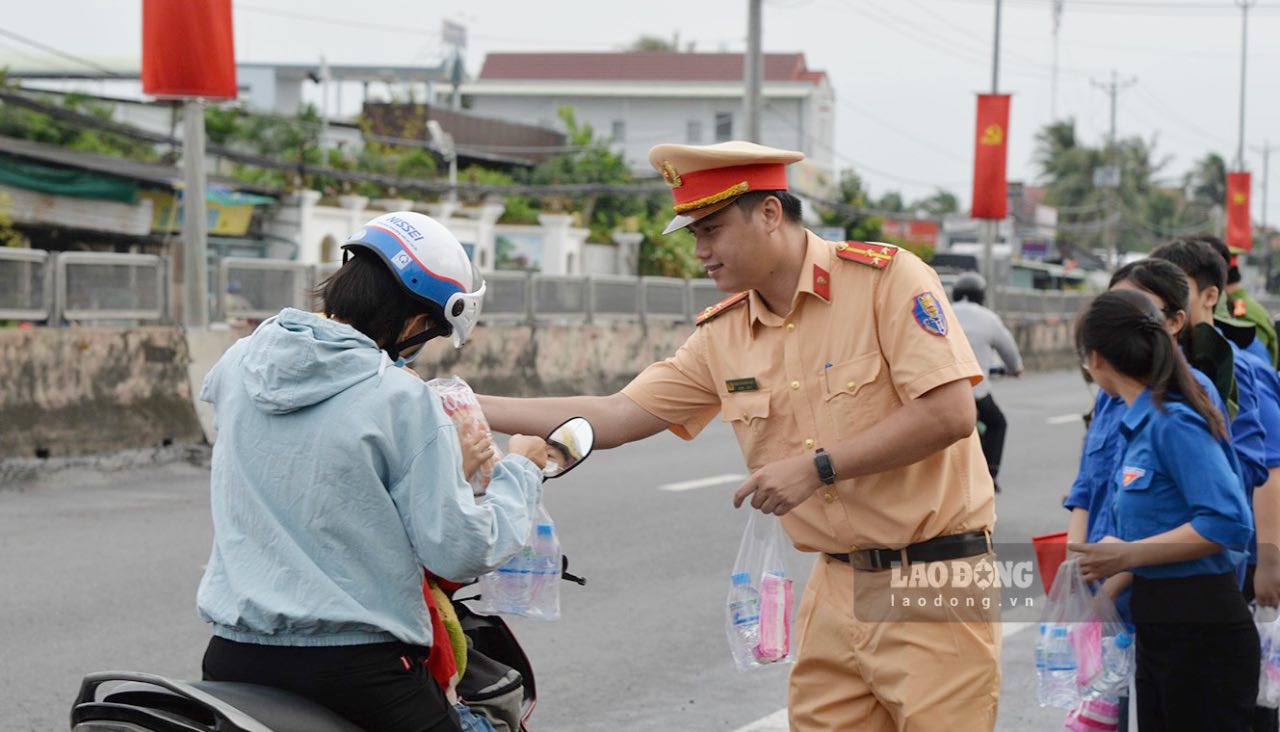 Luc luong Canh sat giao thong Cong an tinh Dong Thap phat mien phi nuoc uong dong chai, khan lanh cho nguoi dan ve que dip Le Quoc khanh 2.9. Anh: Quyen Pham