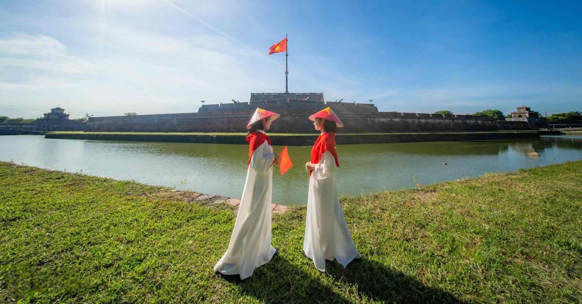 Doi ban tre mac ao dai truyen thong, chup hinh tai khu vuc Phu Van Lau, doi dien Ky Dai. Anh: Bao Minh