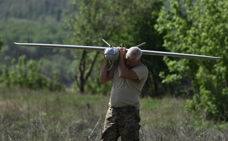 A Ukrainian soldier carrying a drone. Photo: AFP