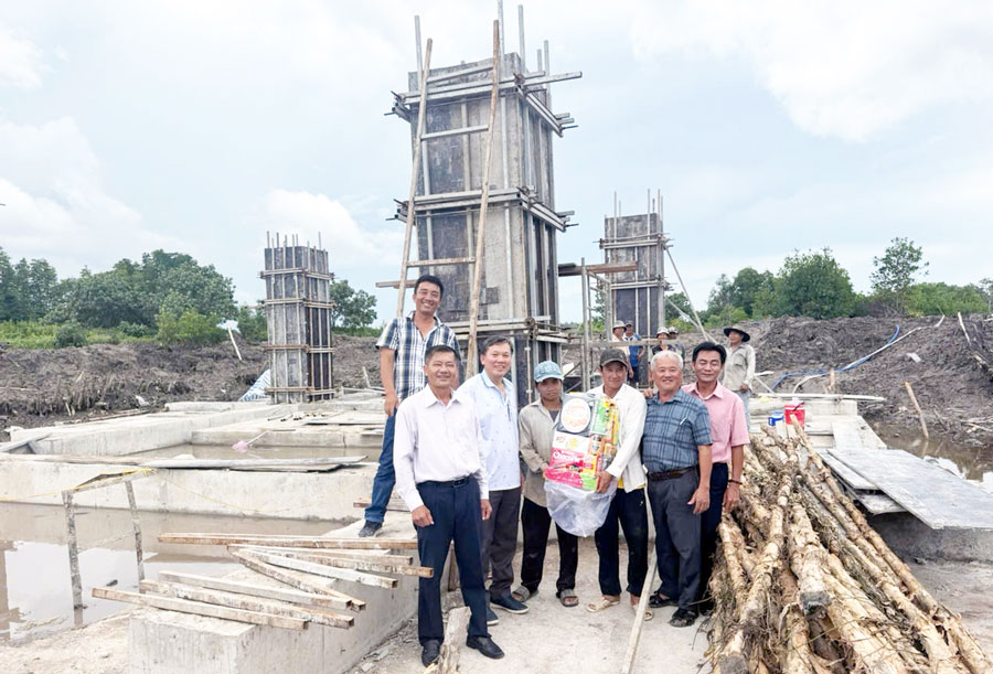 Pho Tong Giam doc EVNSPC Lam Xuan Tuan (thu 2 ben trai qua) kiem tra tien do, tang qua nha thau thi cong tai du an “Xuat tuyen duong day 110kV mach kep tu tram 220kV Nam Can”. Anh: EVNSPC