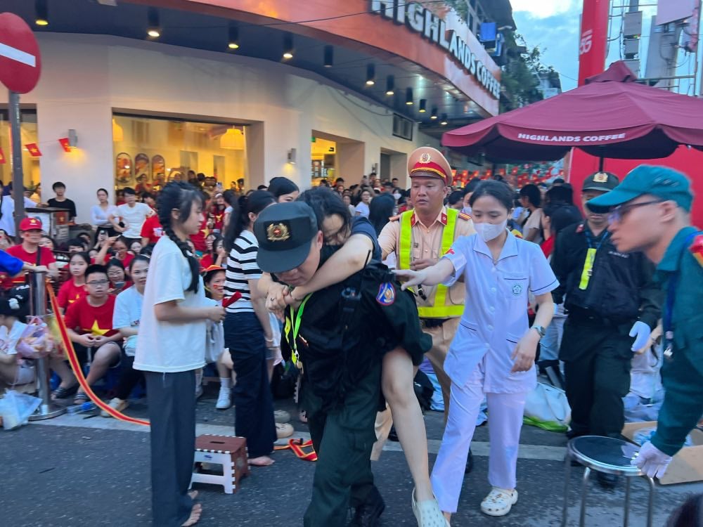 A woman suddenly fainted from low blood pressure while watching a parade. Photo: Cuong Ngo
