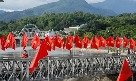 Cầu Mường Thanh (phường Điện Biên Phủ, tỉnh Điện Biên) rực sắc đỏ dịp Tết Độc lập. Ảnh: Quang Đạt