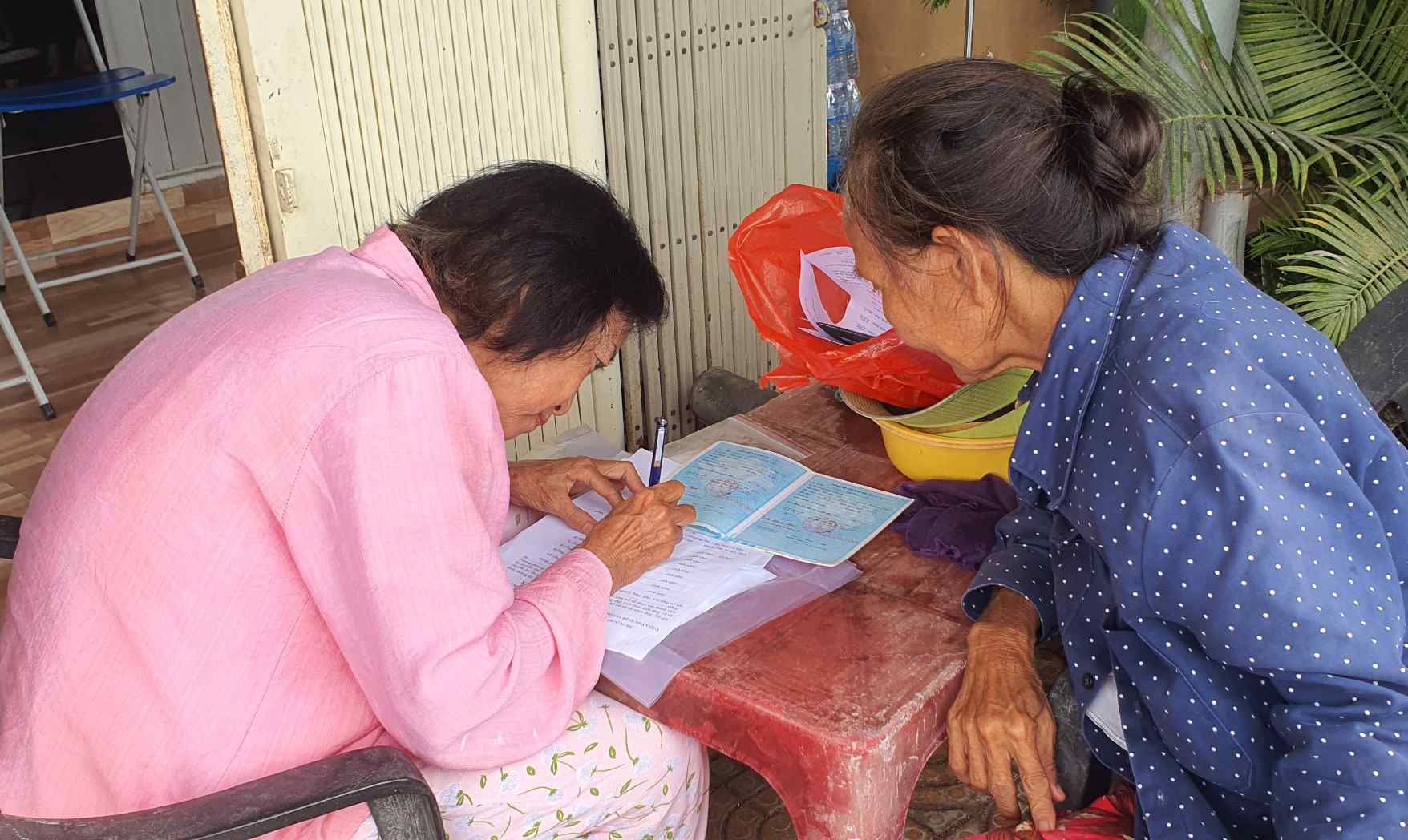 Ca Mau people help each other declare household members to receive gifts from the Government. Photo: Nhat Ho