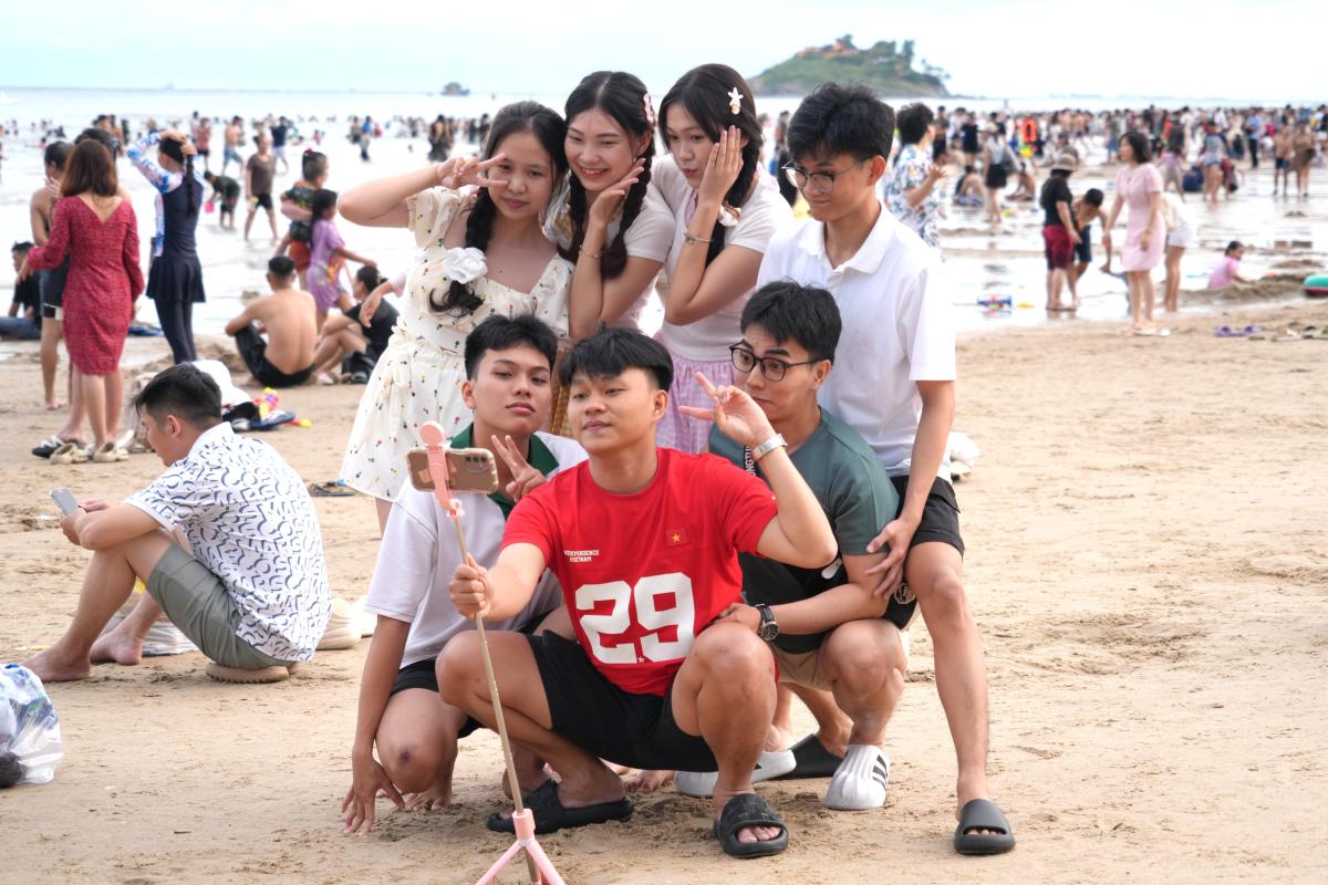 Nhom du khach check-in tren bai tam o Vung Tau chieu 31.8. Anh: Thanh An
