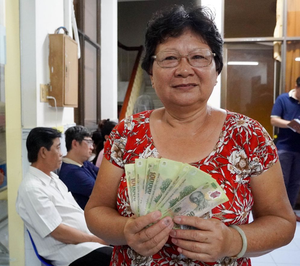 Ba Luong Thi Tuyet Lien (sinh nam 1964), nguoi dau tien nhan duoc tien, cho biet khi nghe dia phuong thong bao, ba tranh thu den som nen nhanh chong hoan tat. “Toi nhan qua cho ca gia dinh 8 khau, tong cong 800.000 dong. Le Quoc khanh nay vui qua, du phai cho mot chut cung khong sao vi chac chan se duoc nhan“, ba Lien chia se.