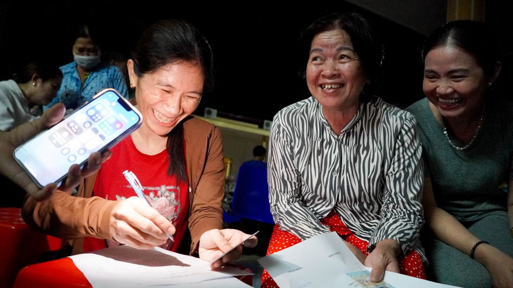 Co Lam Que Thanh - giao vien Truong Tieu hoc My Xuyen 2 (phuong My Xuyen, TP Can Tho) den lam thu tuc nhan qua cho 4 thanh vien trong gia dinh. Ngoai ghi thong tin cho minh, co con ho tro ghi cho nguoi dan den nhan cung.