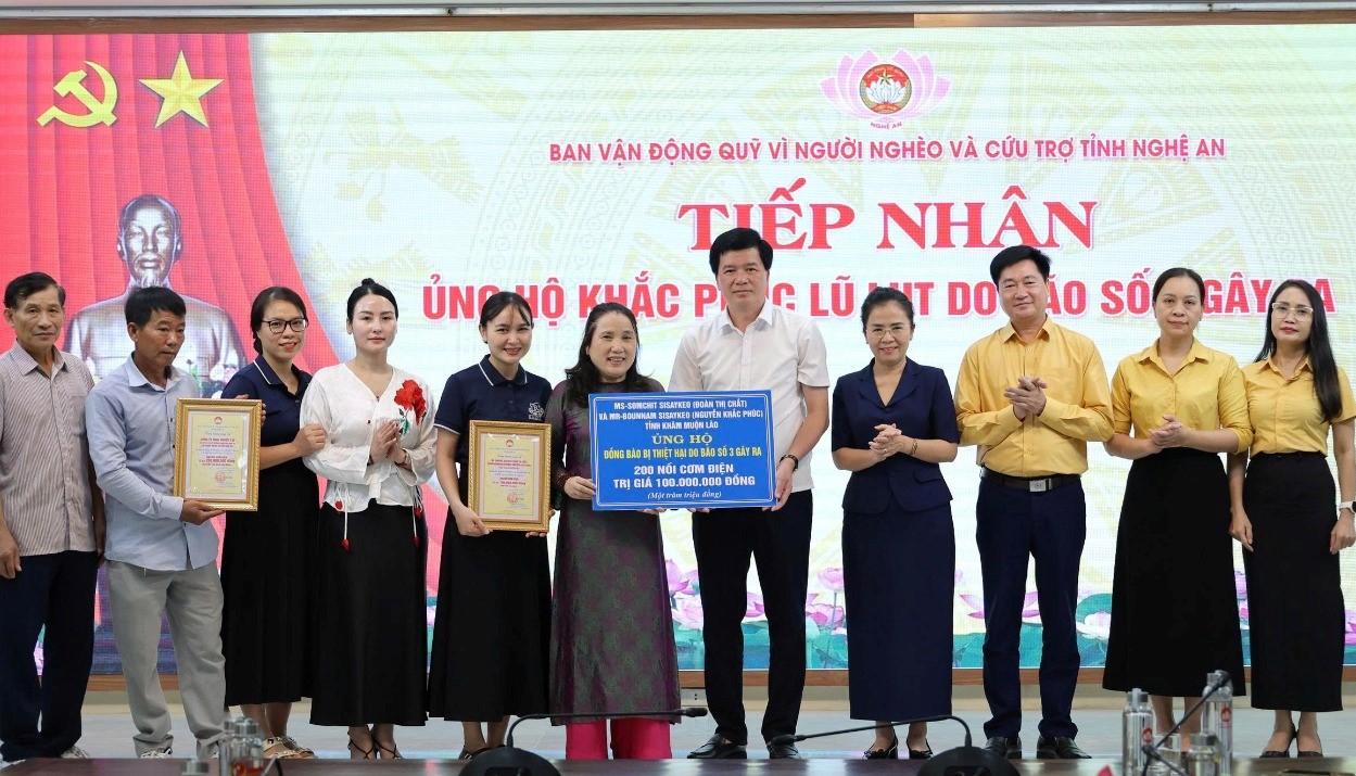 Doanh nhan Somchit Sisaykeo (Doan Thi Chat) va Bounnam Sisaykeo (Nguyen Khac Phuc) trao tang 200 noi com dien ung ho dong bao vung lu Nghe An. Anh: Ngoc Anh