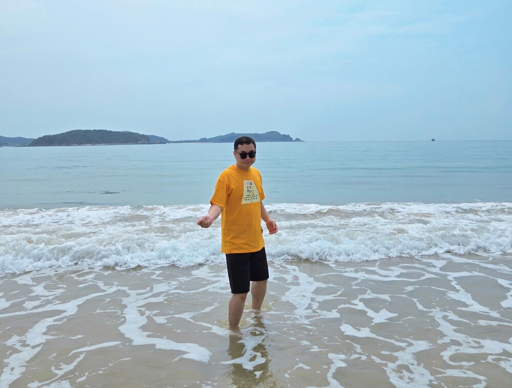 오렌지색 티셔츠는 남성들이 여름 해변 여행에서 돋보이도록 도와줍니다. 사진: 뚜언 닷