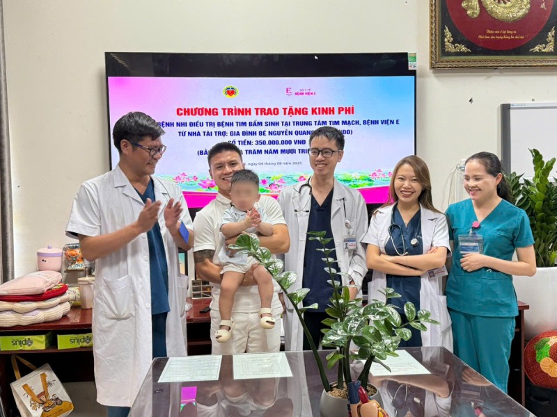 Midfielder Quang Hai and his son give support money to the representative of Hospital E. Photo: Provided by the character