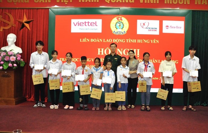La Federation du travail de la province de Hung Yen remet des bourses et des lampes d'etude aux enfants d'ouvriers en difficulte qui sont bons eleves. Photo : Thu Nguyet