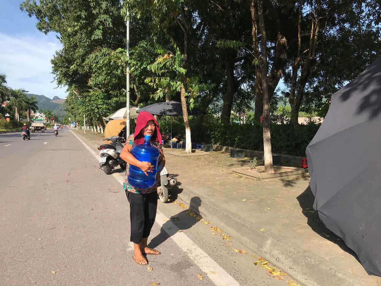 Giua thoi tiet gan 40 do C, co Hanh van go lung om binh nuoc lon, tat ta muu sinh tren via he. Anh: Yen San